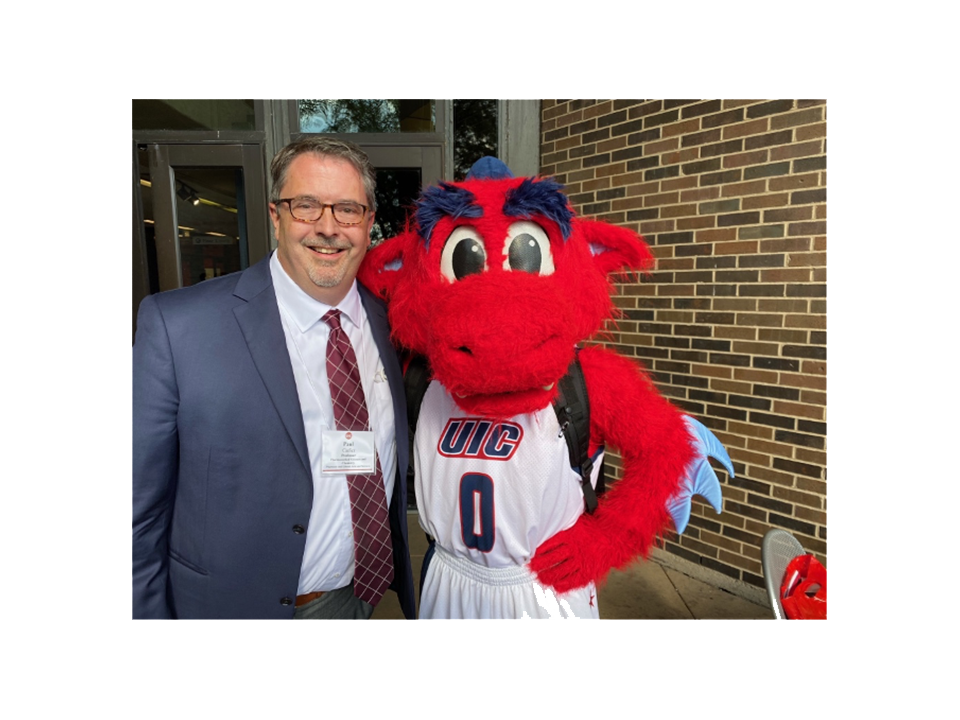 Sir Paul Carlier posing for a picture with UIC mascot, Sparky