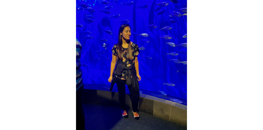 Dee Dee Keen standing in front of a large acquarium