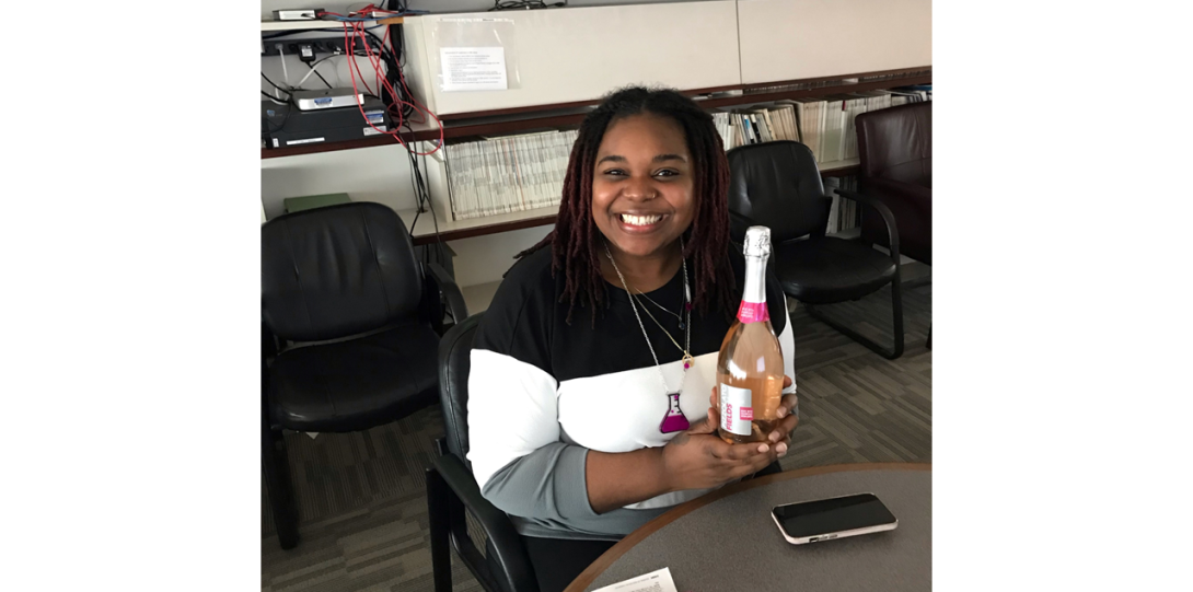 Diandra Myriame Vaval Taylor smiling with a bottle of pink champagne