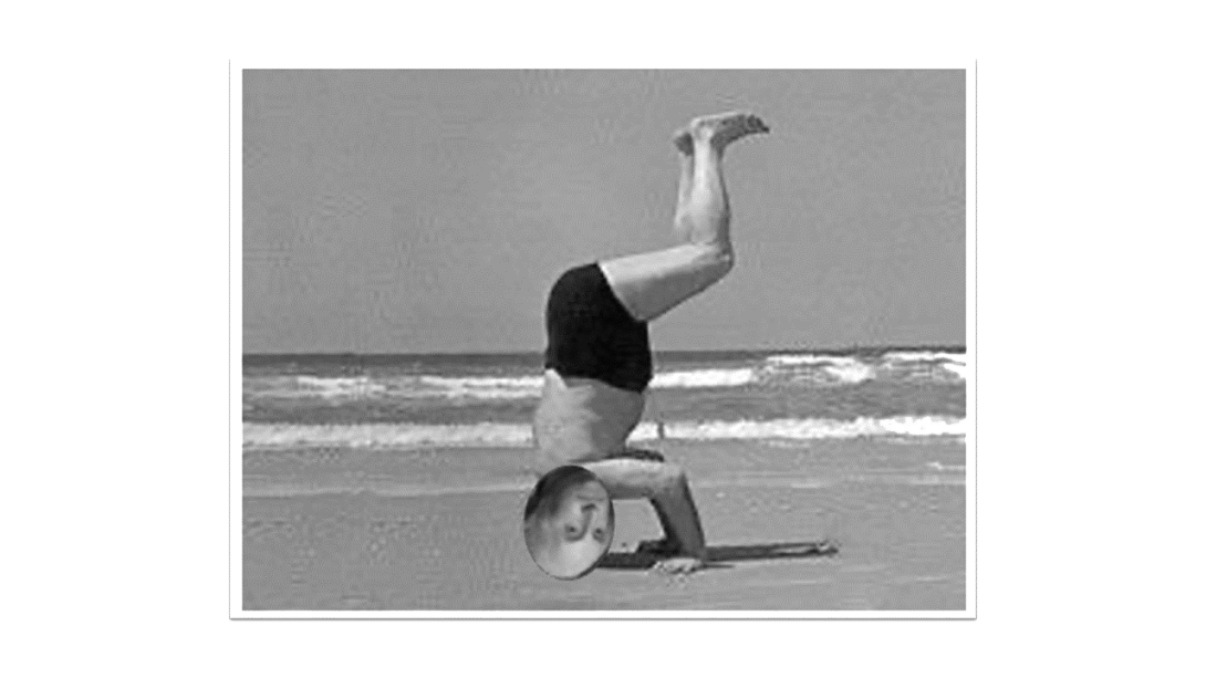 Man standing on his head at the beach